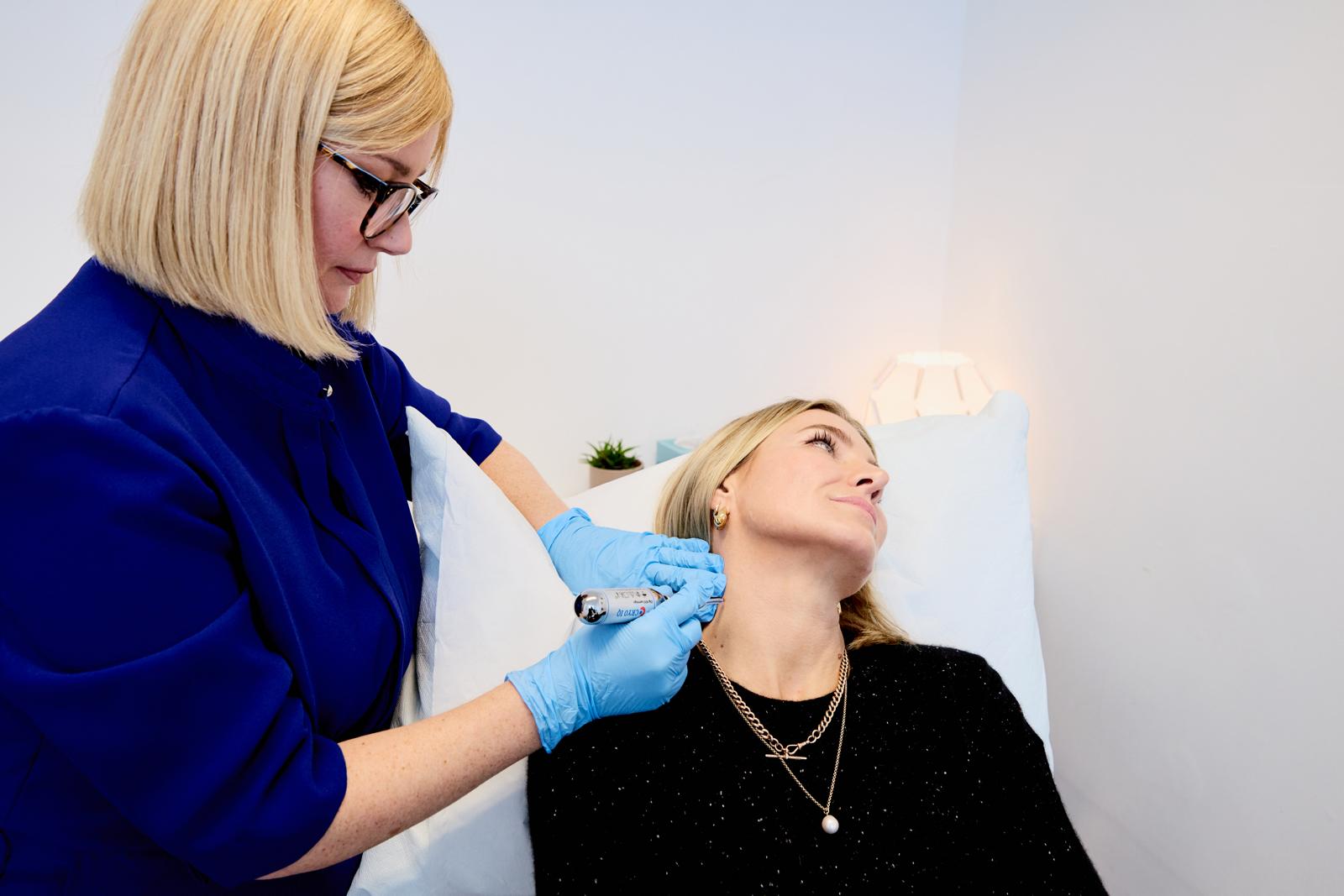 Dr Lorraine Kemp carrying out a skincare treatment in clinic